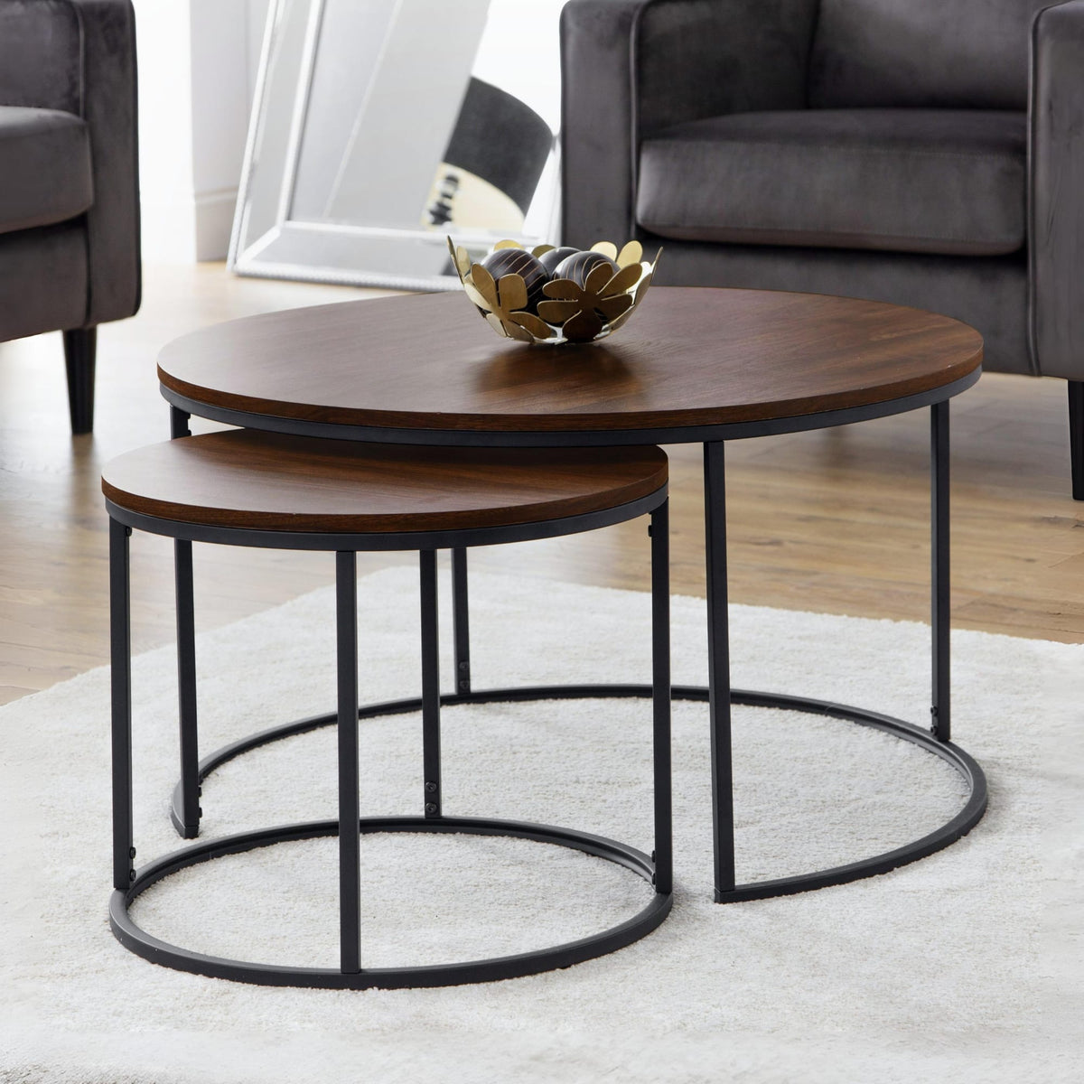 Set of two wooden coffee tables with metal legs in a living room setting.