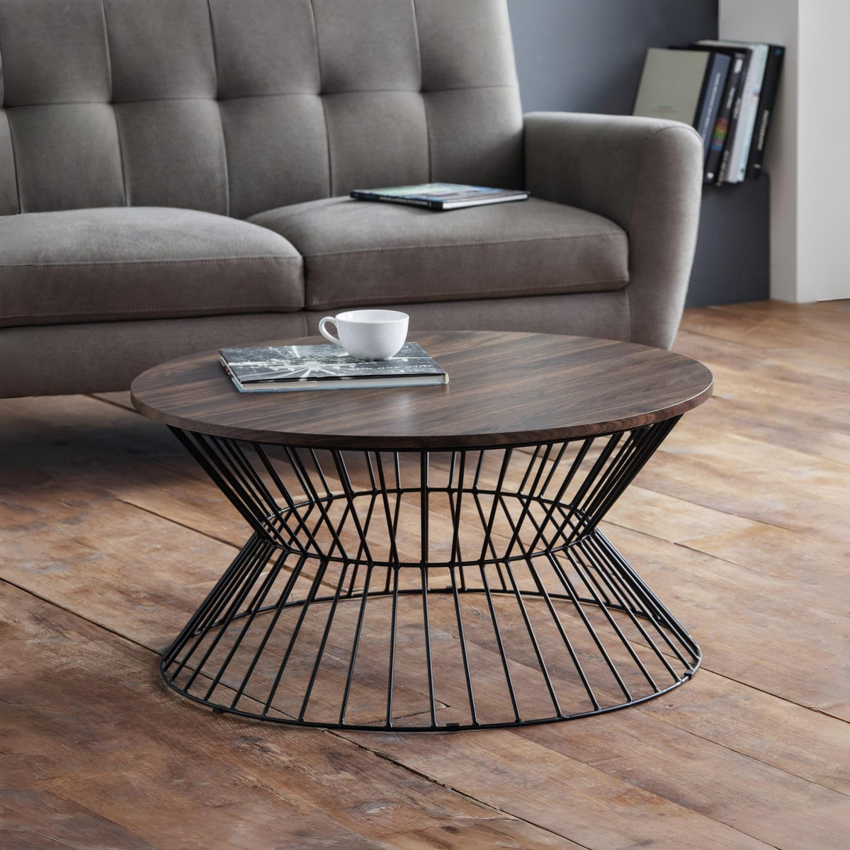Round wooden coffee table with metal base in a living room setting