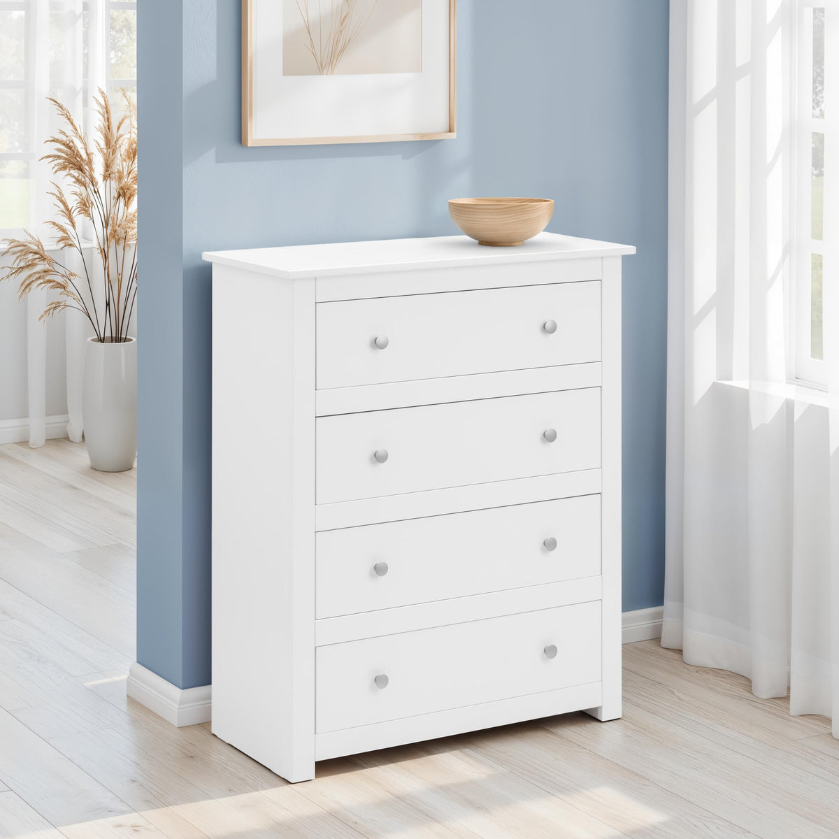 White dresser with four drawers against a blue wall in a room with natural light.