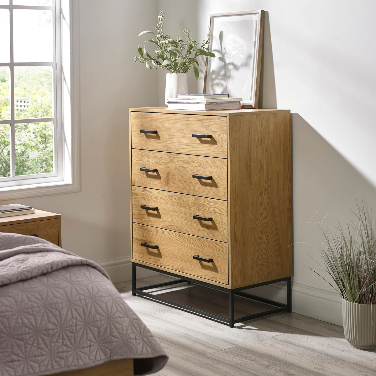Wooden dresser with four drawers in a bedroom setting