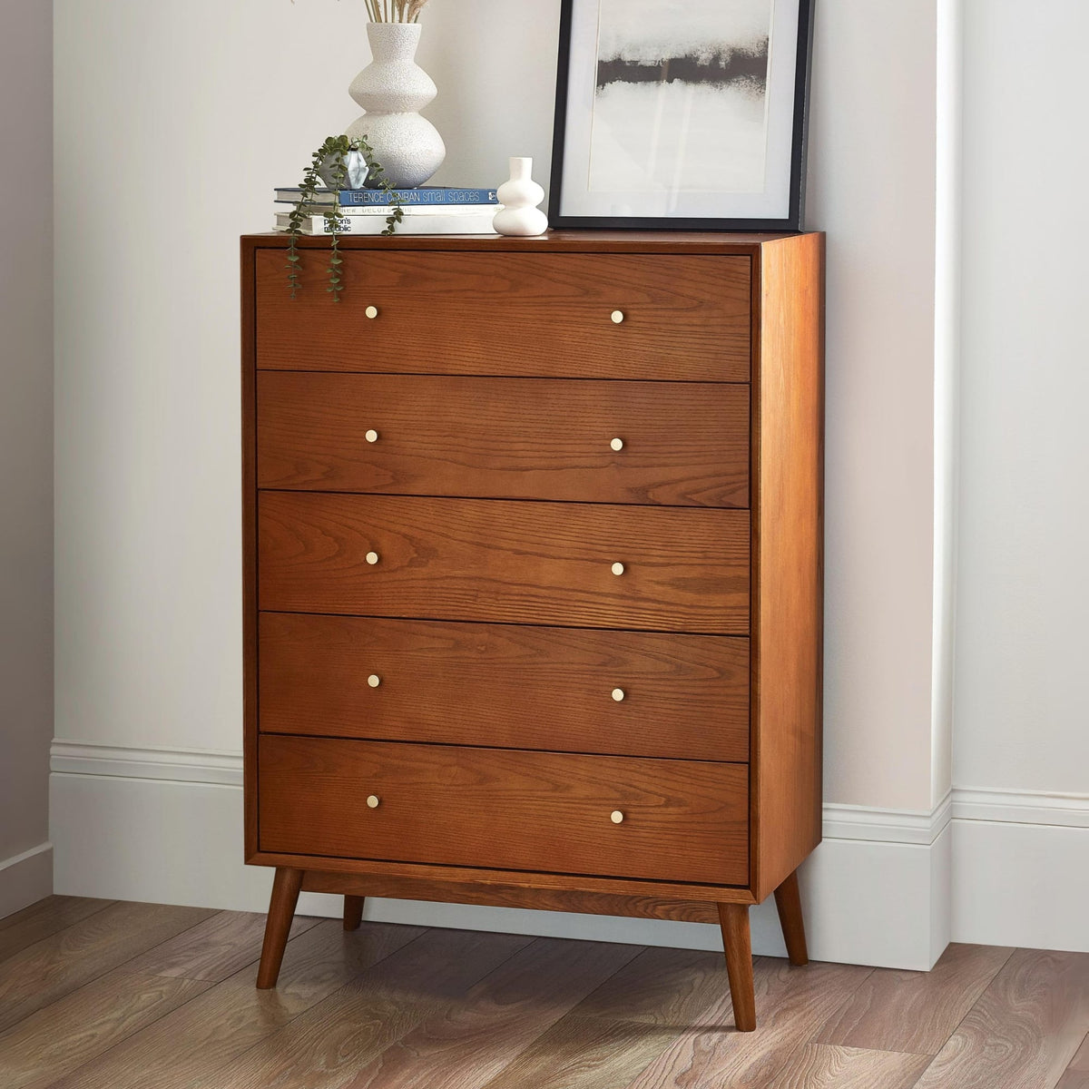 Wooden dresser with four drawers in a room setting.