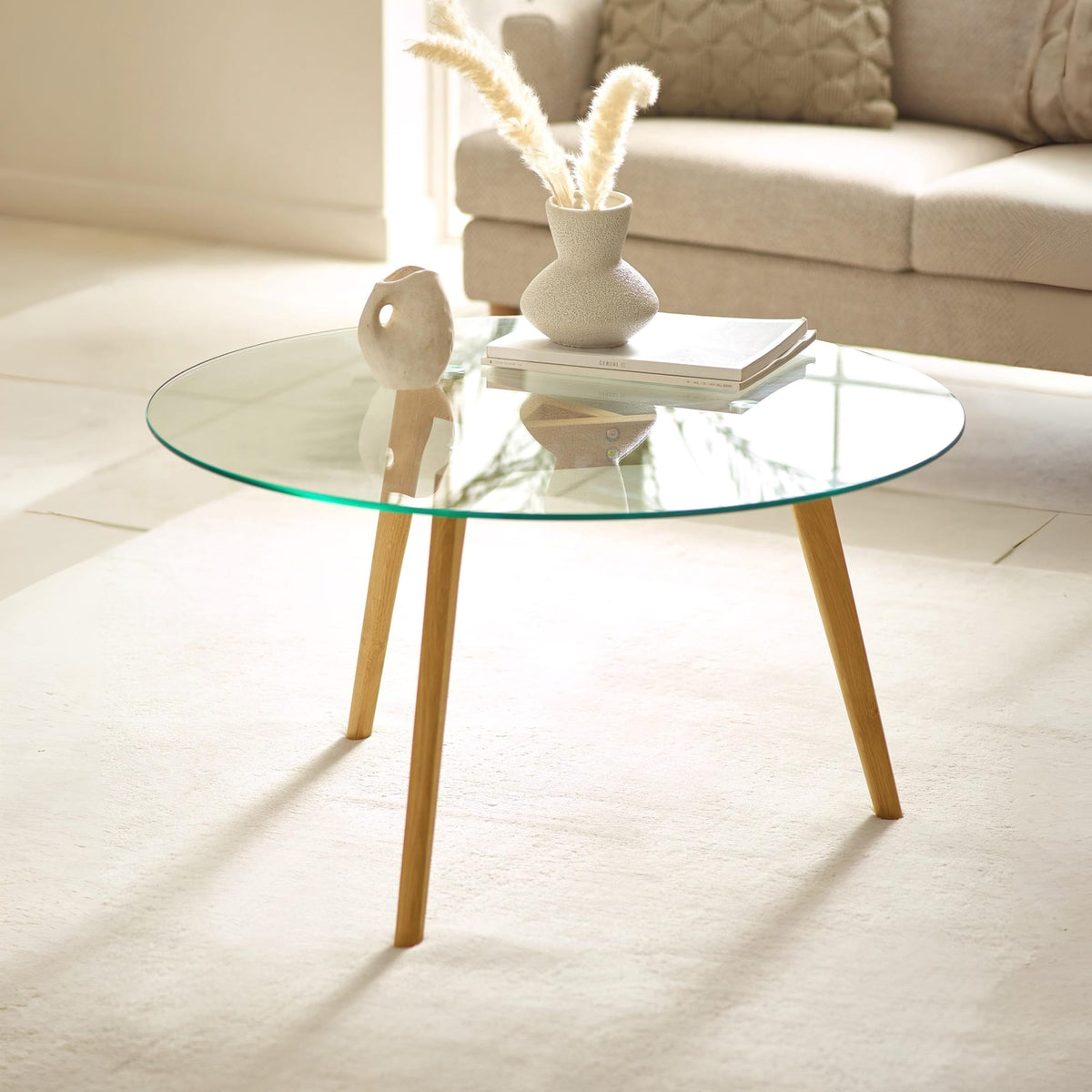 Glass coffee table with wooden legs in a living room setting