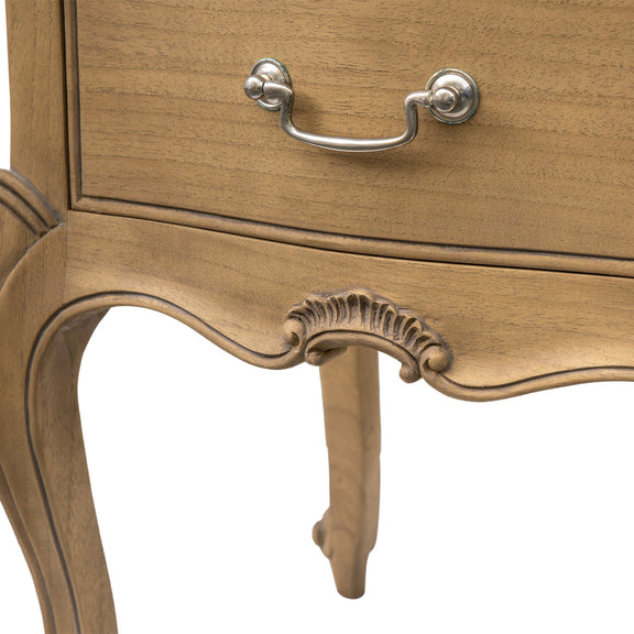 Close-up of a wooden drawer with decorative carvings and a metal handle on a white background.