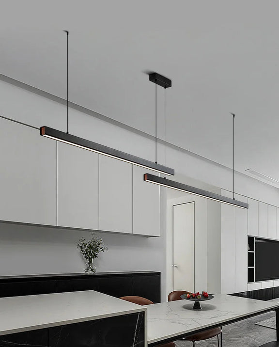 Slim black linear LED pendant light installed above a modern dining table.