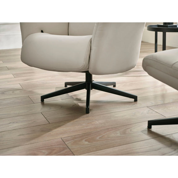 Beige armchair with black metal legs on a wooden floor