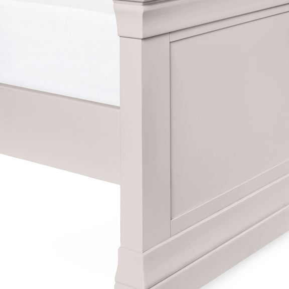 Close-up of a light gray wooden bed frame corner on a white background