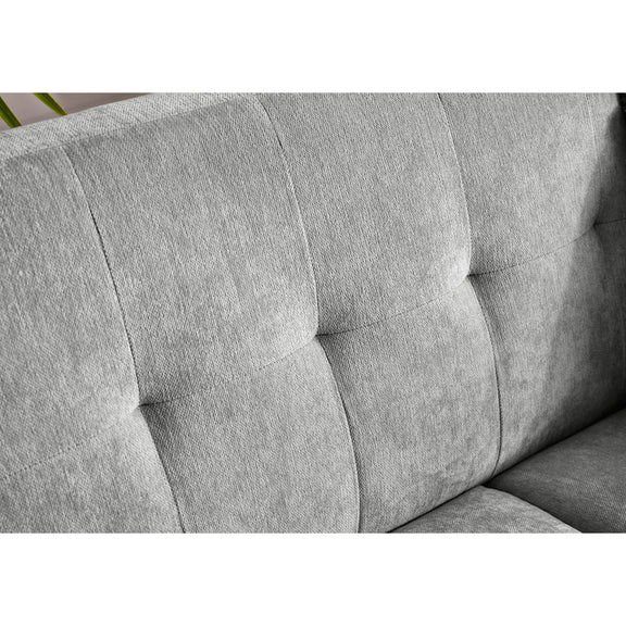Gray upholstered chair with tufted design on a white background
