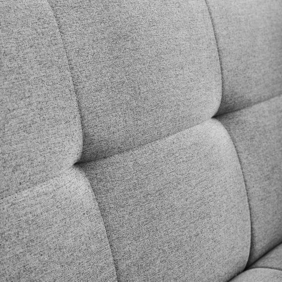 Close-up of a gray upholstered chair with a textured fabric.