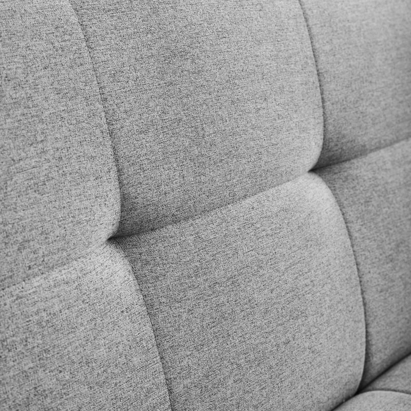 Close-up of a gray upholstered chair with a textured fabric.
