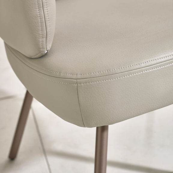 Close-up of a beige chair with visible stitching on a light background