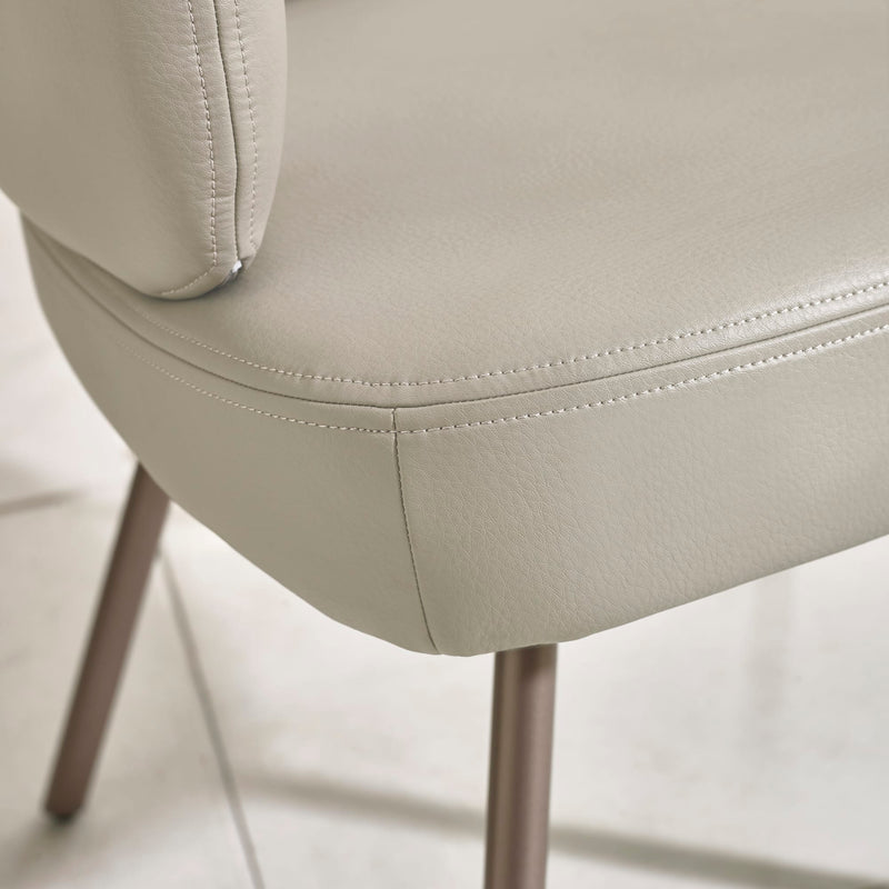Close-up of a beige chair with visible stitching on a light background