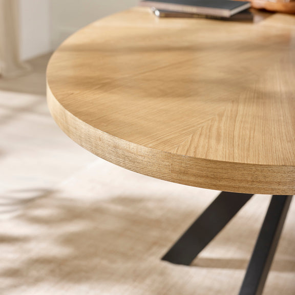 Round wooden table with black metal legs on a light background