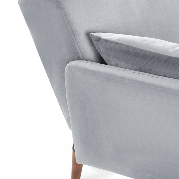 Gray velvet armchair with a cushion on a white background