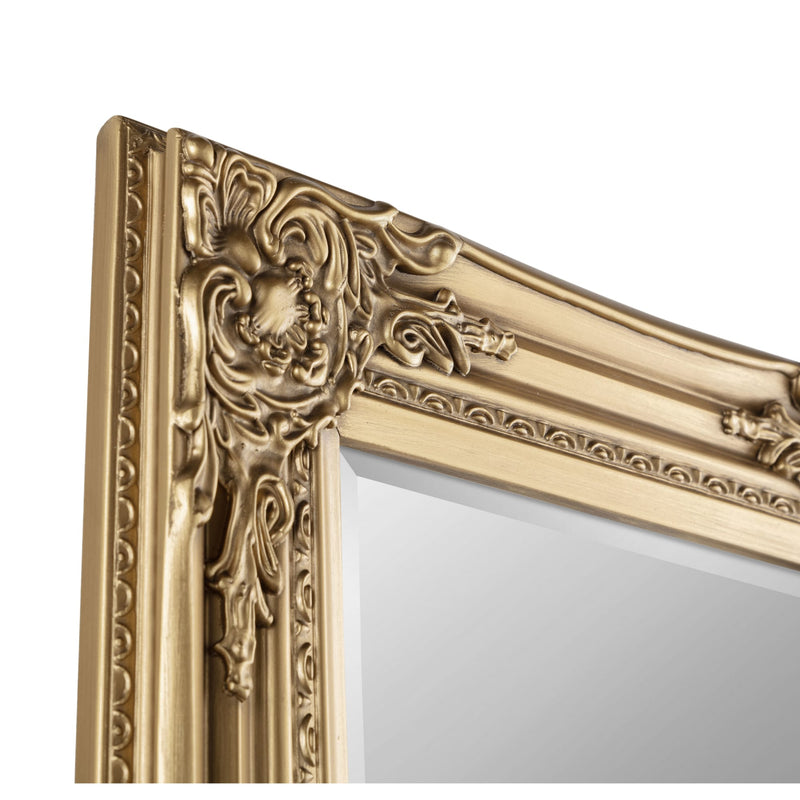 Decorative gold mirror with intricate patterns on a white background