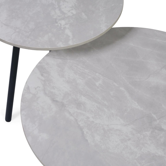 Two gray marble side tables with a black metal leg on a white background