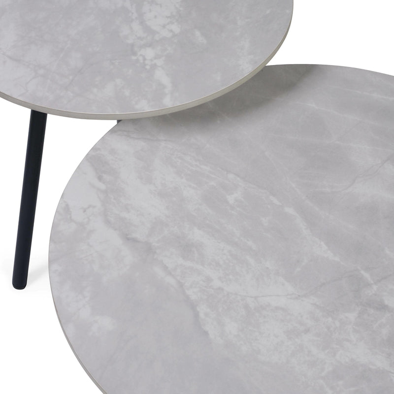 Two gray marble side tables with a black metal leg on a white background
