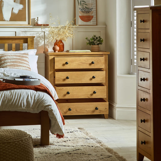 Wooden dresser in a bedroom with a bed and decor