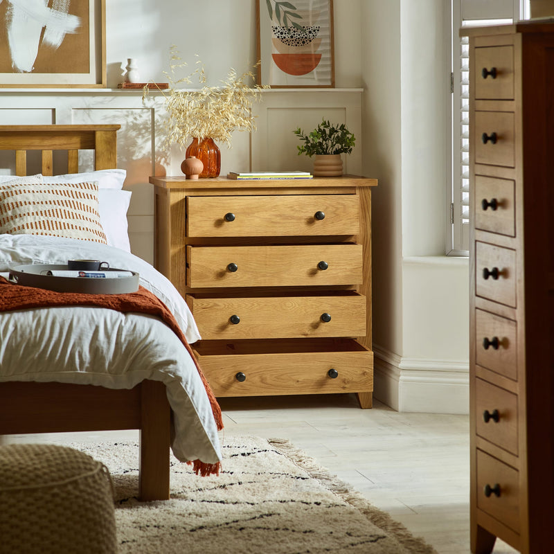 Wooden dresser in a bedroom with a bed and decor