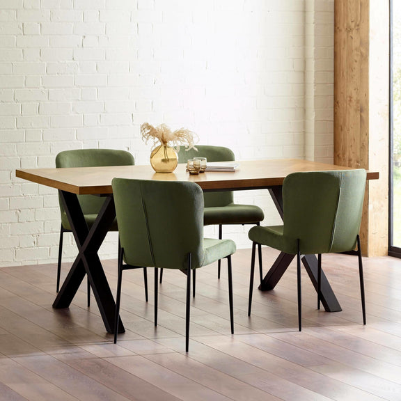 Dining table with four green chairs in a modern interior setting.