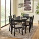Dining room with a black table and chairs on a patterned rug.