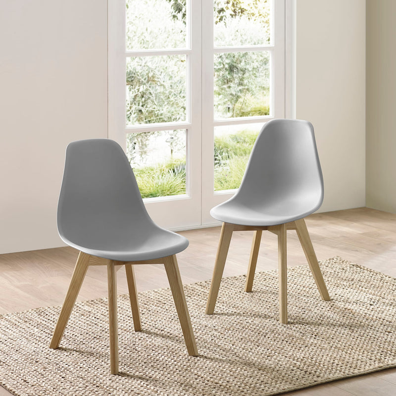 Two gray chairs with wooden legs in a room with large windows.