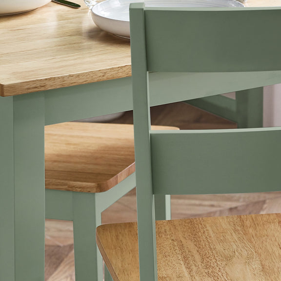 Green dining chair with wooden seat and table in a kitchen setting