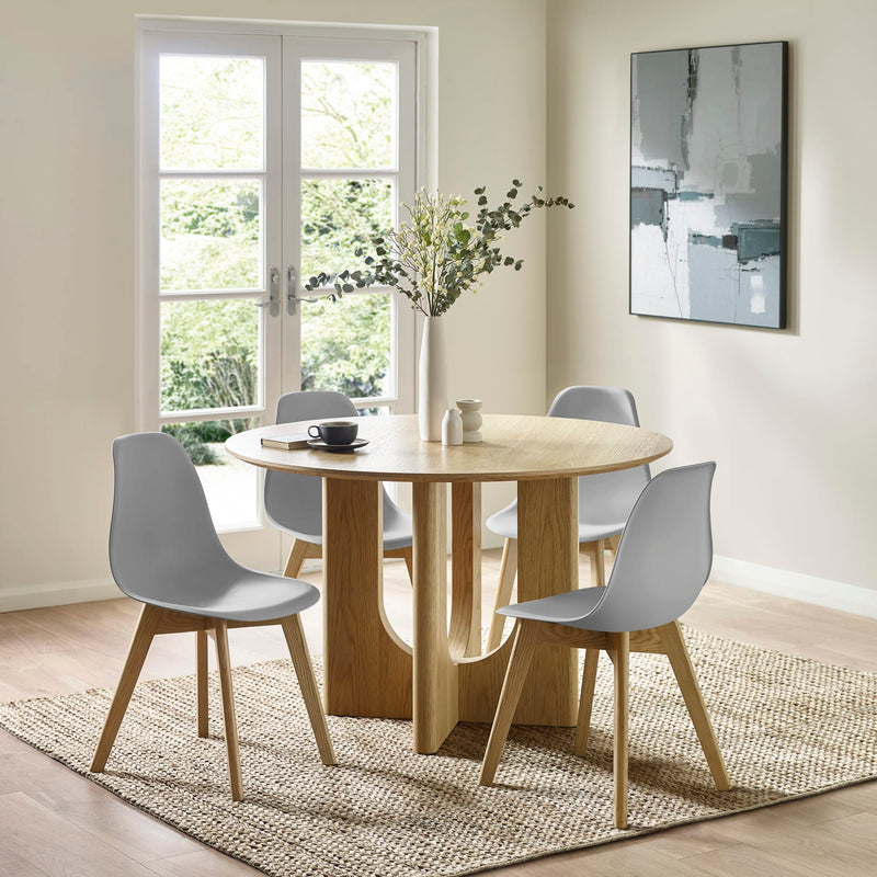 Dining room with a round wooden table and four gray chairs.