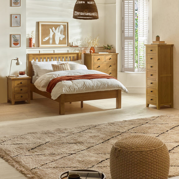 Wooden bedroom furniture set with bed, nightstands, and dresser in a well-lit room.