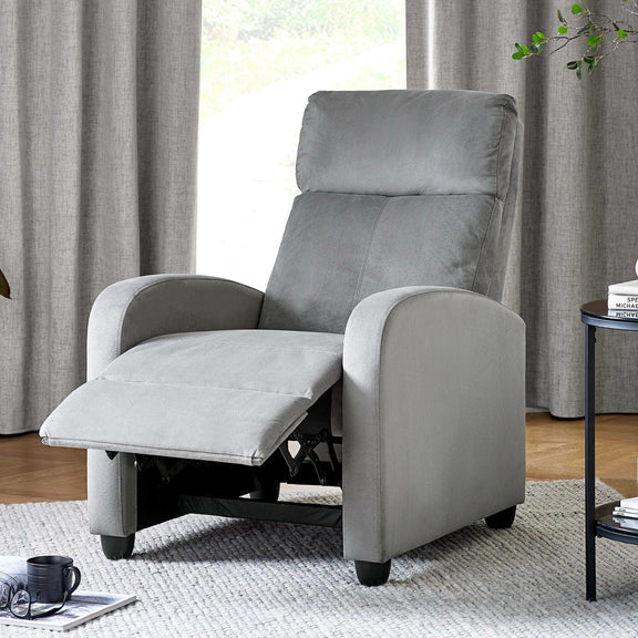 Gray recliner chair in a living room setting with curtains and a side table.