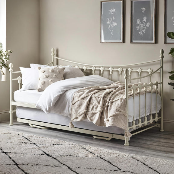 White metal bed with bedding in a bedroom setting