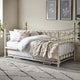 White metal bed with bedding in a bedroom setting