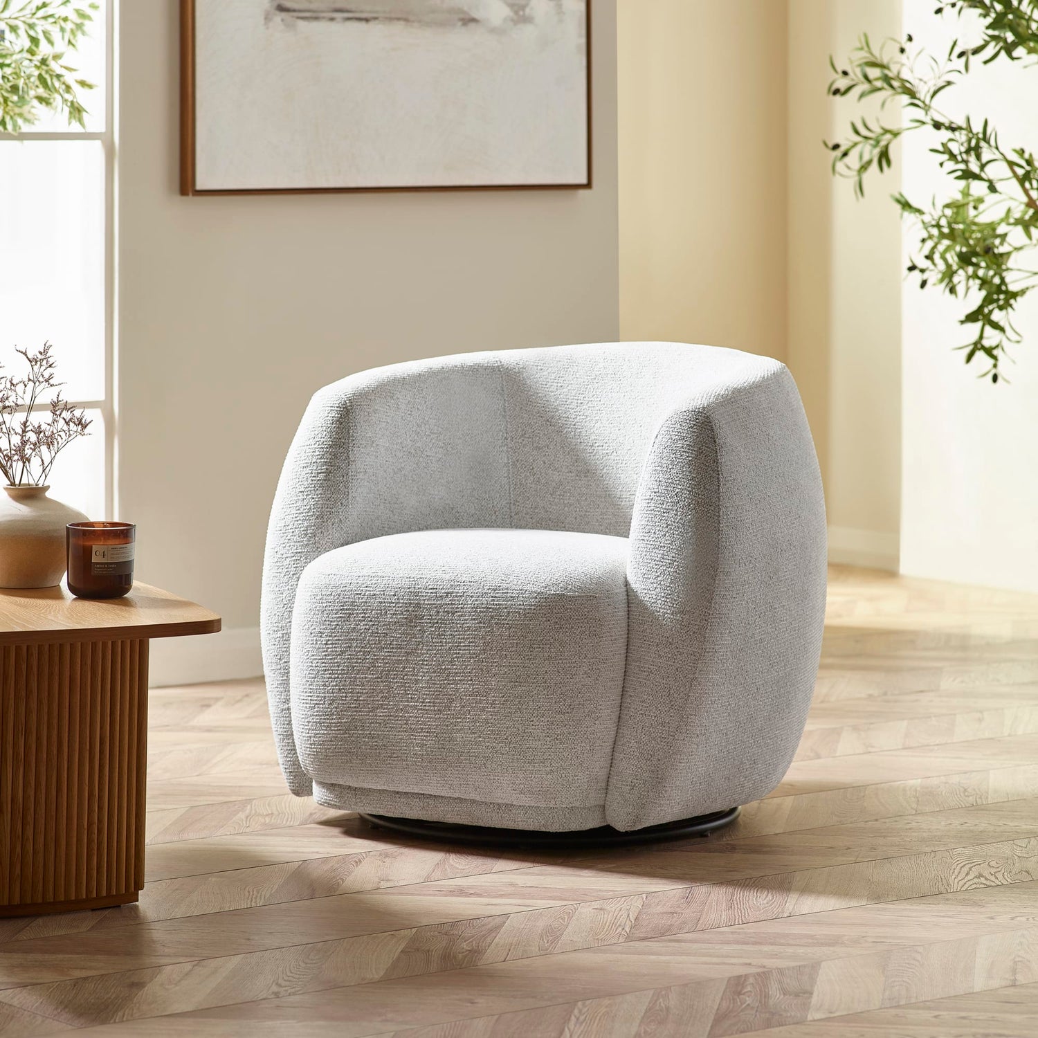 Gray armchair in a room with a wooden floor and a small table.