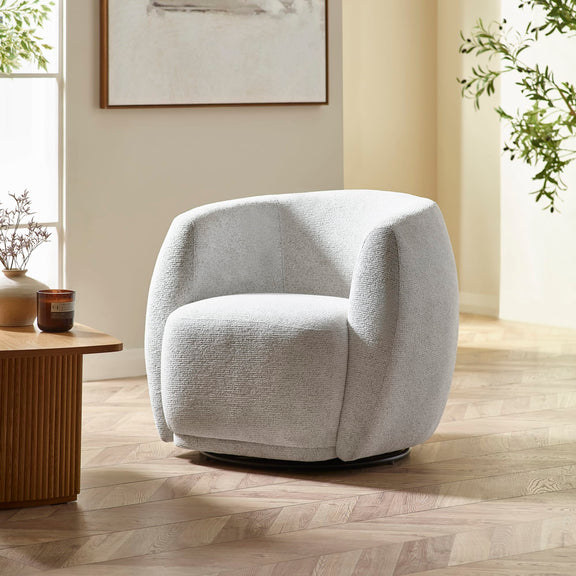 Gray armchair in a room with a wooden floor and a small table.