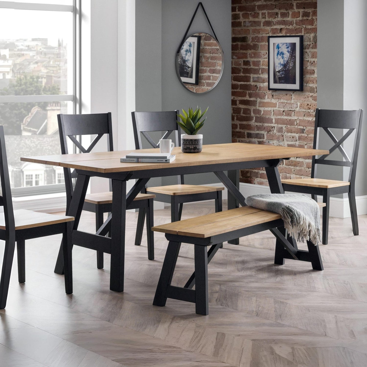 Dining room with a wooden table and chairs against a brick wall.