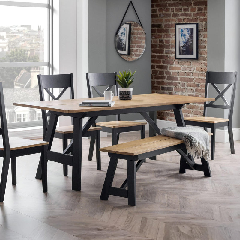 Dining room with a wooden table and chairs against a brick wall.
