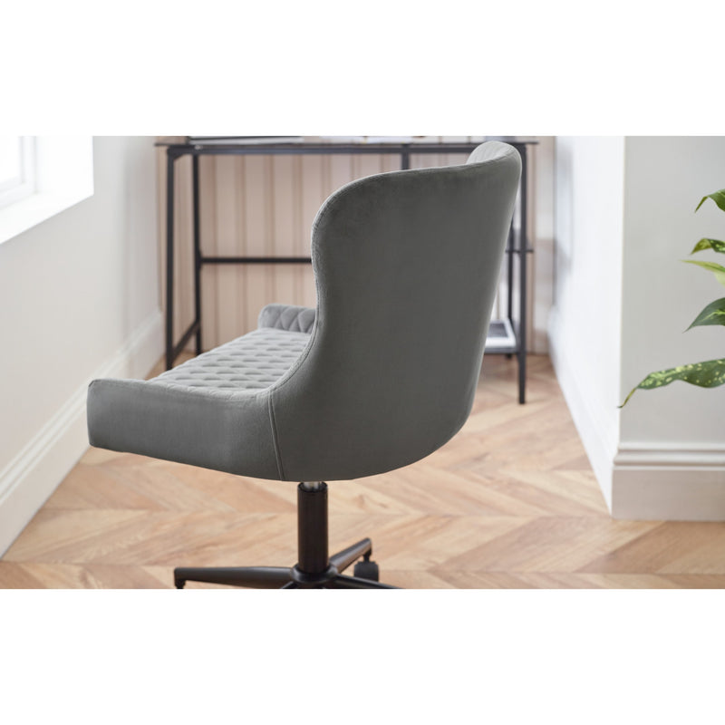 Gray office chair on a wooden floor with a blurred background