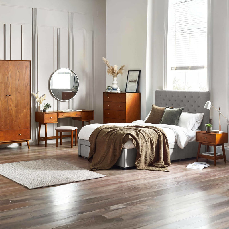 Modern bedroom with wooden furniture and a bed with pillows.