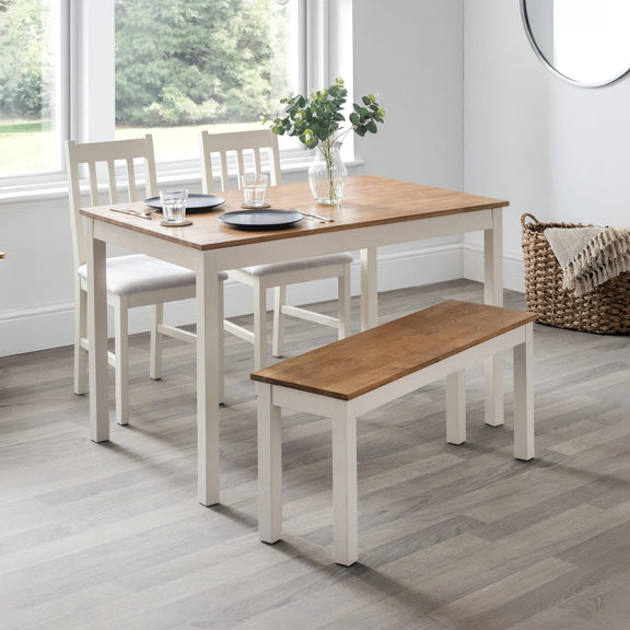 Dining room set with a table, chairs, and bench in a bright room.