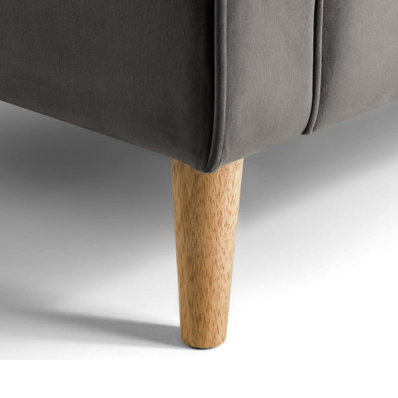 Gray upholstered chair with a wooden leg on a neutral background