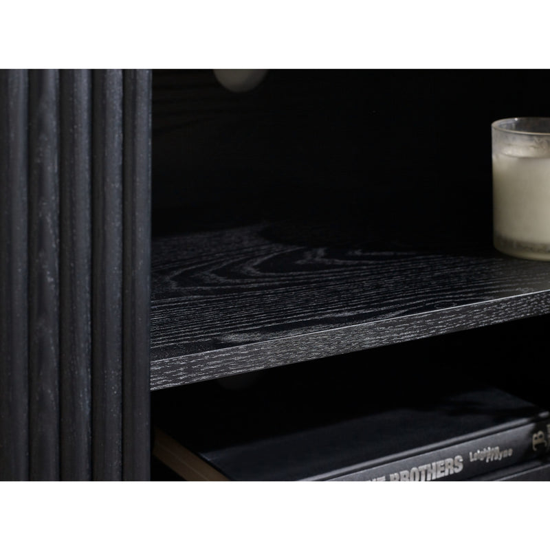 Close-up of a shelf with a candle and books against a dark background