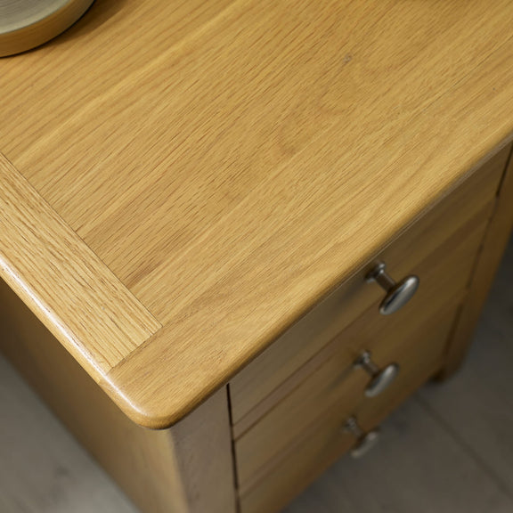 Wooden cabinet with a visible grain pattern and metal handles.