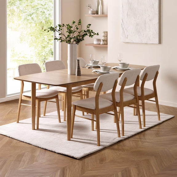Dining room with wooden table and chairs on a white rug