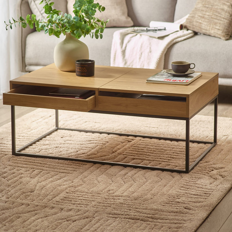Wooden coffee table with a vase, cup, and book in a living room setting.