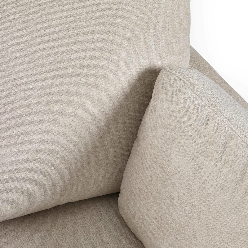 Close-up of a beige upholstered chair corner