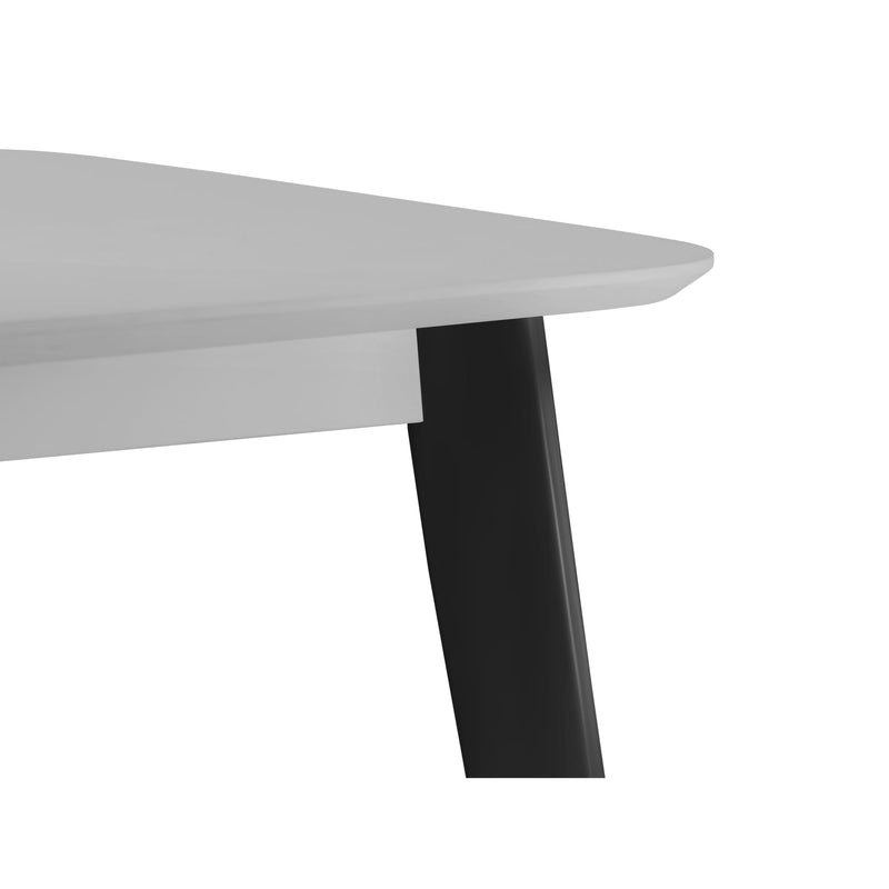 Close-up of a modern table with a white top and black leg on a white background