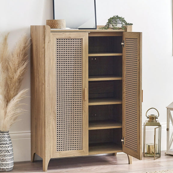 Wooden cabinet with open doors displaying shelves, placed against a white wall.