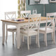 Dining room with a wooden table and white chairs on a gray floor.