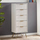 Tall white cabinet with gold legs against a gray wall