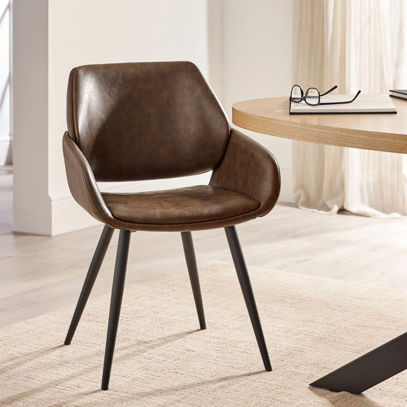 Brown leather chair in a room with a desk and glasses on it.