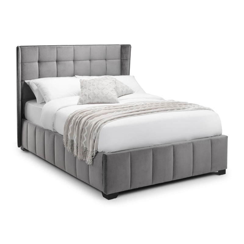Gray upholstered bed with white bedding on a white background